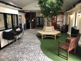 Our lovely indoor garden with outdoor seating, daylight style lighting, and even real plants and speakers playing birdsong to help create an outdoor feeling for our residents.